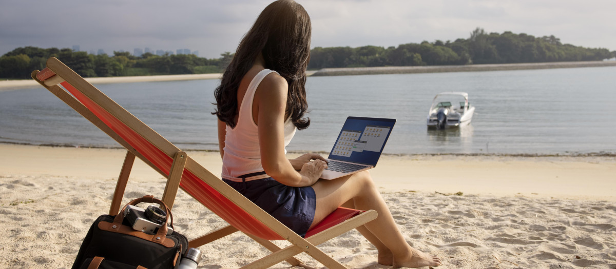 mujer de tiro completo que trabaja en la computadora portatil