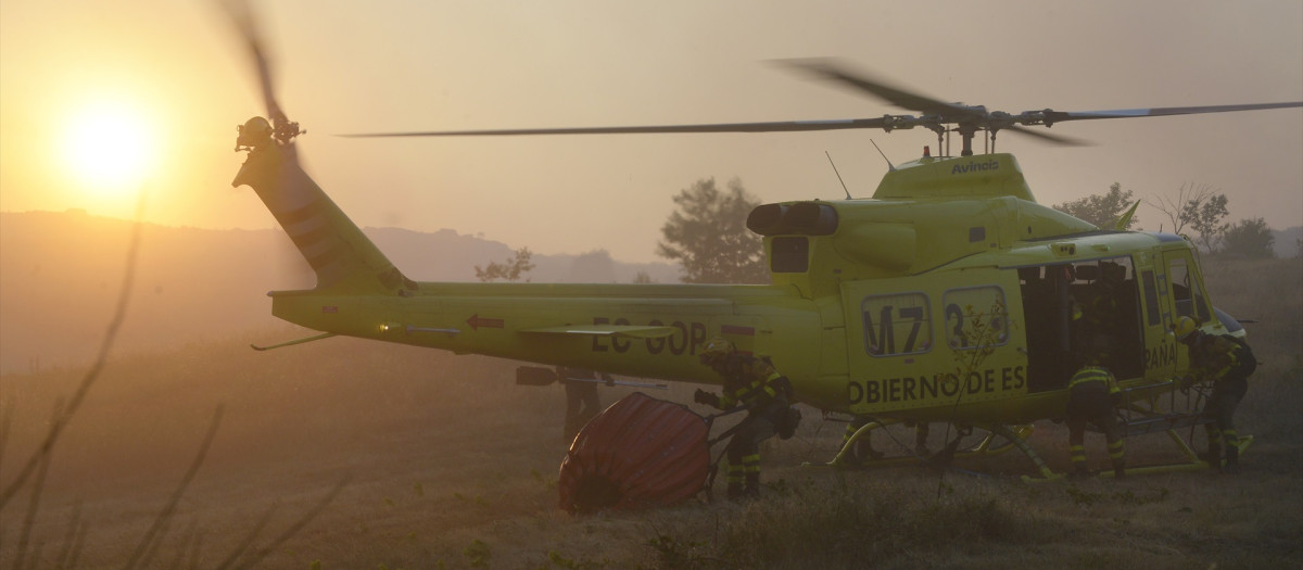 Bomberos preparan el helicóptero para extinguir un incendio en Vilardevós