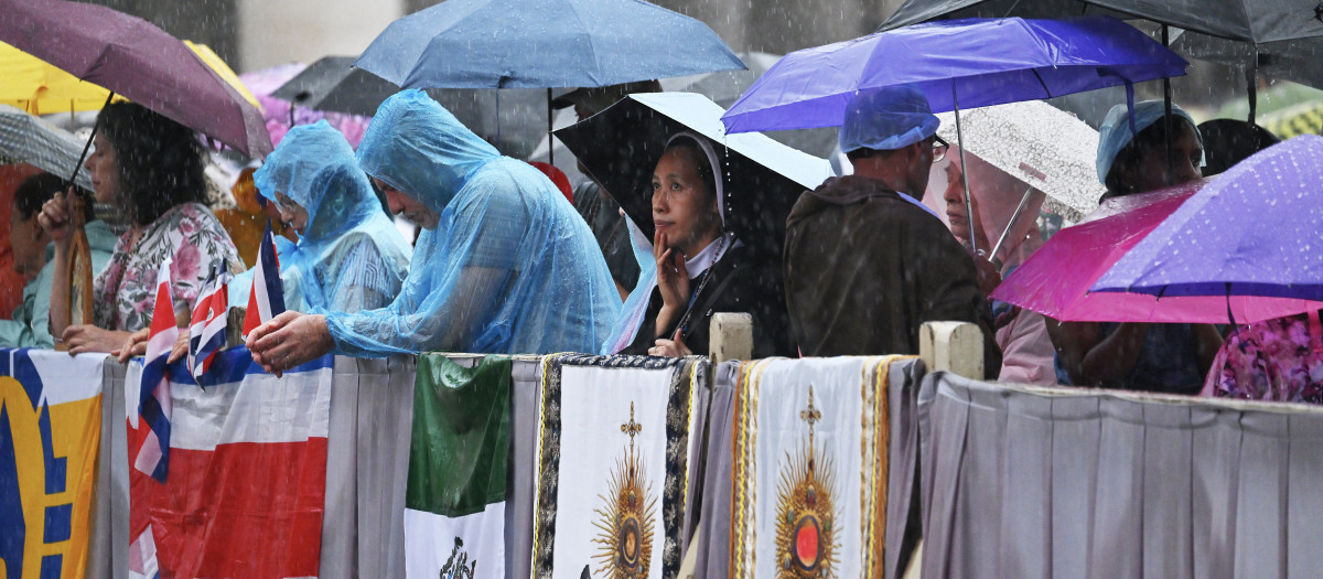 Miles de fieles bajo chubasqueros y paraguas esperando la llegada de León XIV a la Plaza de San Pedro