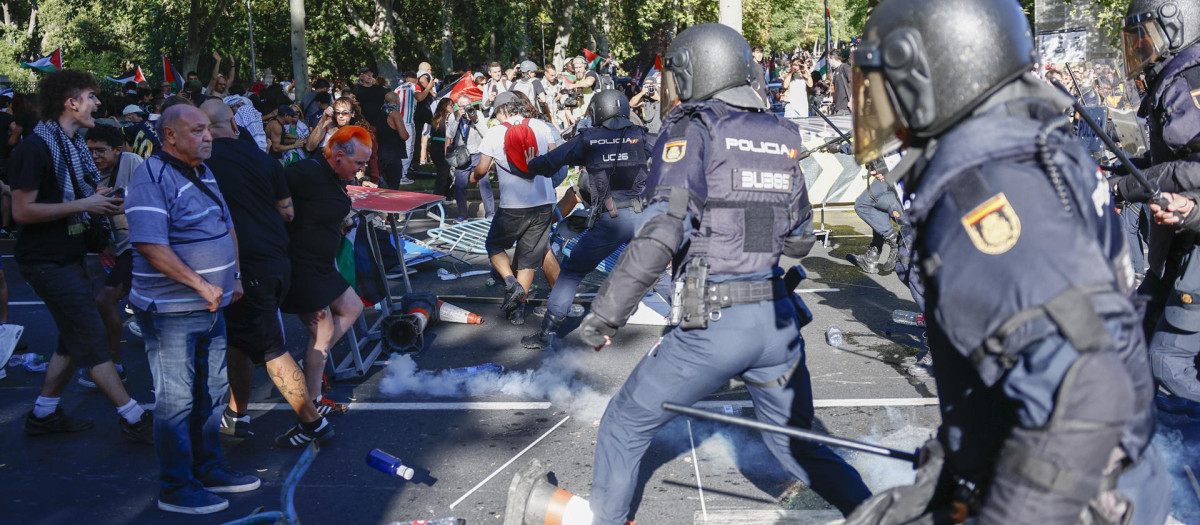 MADRID, 14/09/2025.- La Policía realiza cargas contra los manifestantes propalestinos con el objetivo de despejar el recorrido de los ciclistas en el Paseo del Prado, este domingo, durante la última etapa de la Vuelta a España que se disputa entre las localidades madrileñas de Alalpardo y Madrid, con un recorrido 103,6 Km.- EFE/Rodrigo Jiménez