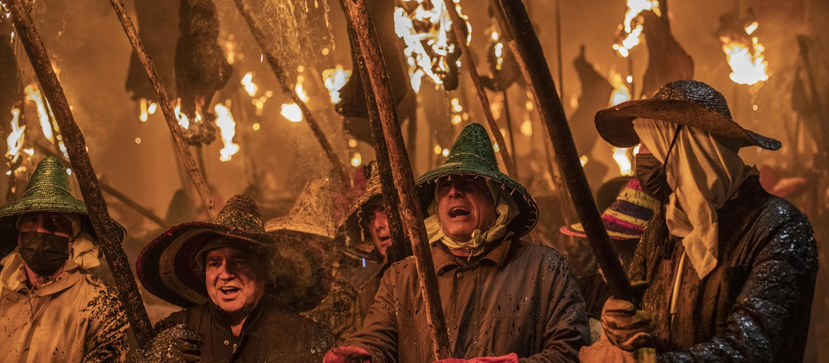 Varias personas caminan con antorchas en la celebración de la Procesión Cívica del Vítor, a 27 de septiembre de 2021, en Mayorga, Valladolid