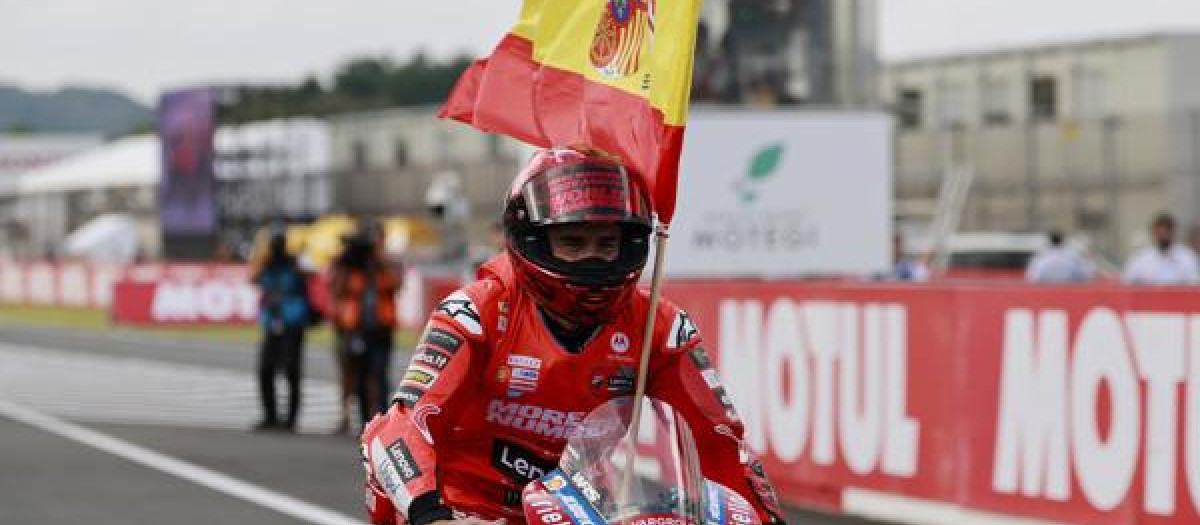 Marc Márquez celebra la victoria con una bandera de España