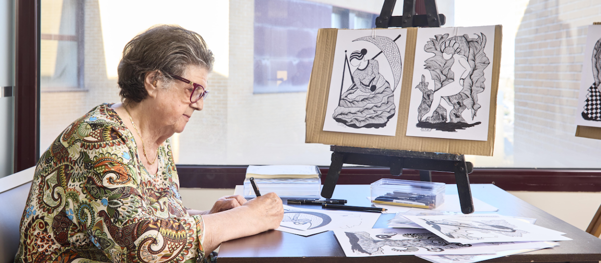 Una persona mayor participa en una actividad de pintura en un centro de día