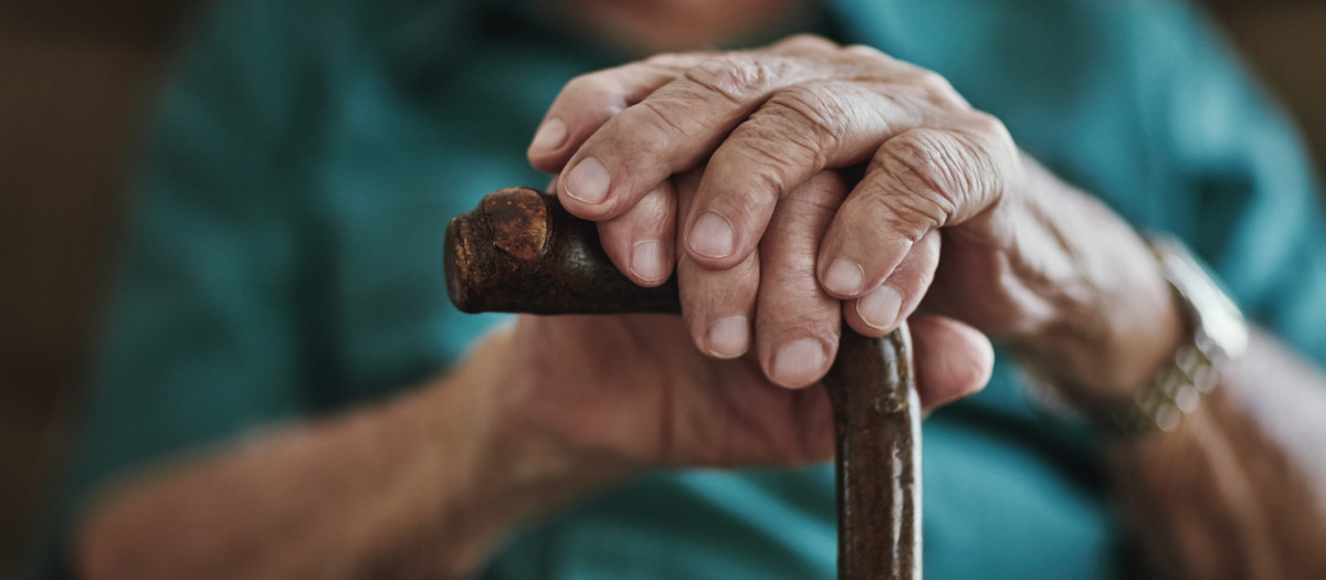 Una persona mayor sostiene un bastón