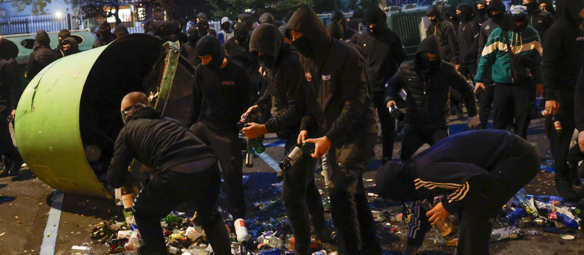 Encapuchados vuelcan los contenedores de vidrio para arrojar las botellas a la Policía