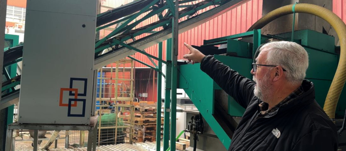 El gerente de "Empordàlia",Simó Casanovas, señalando la máquina de inteligencia artificial que identifica las olivas con mayor calidad