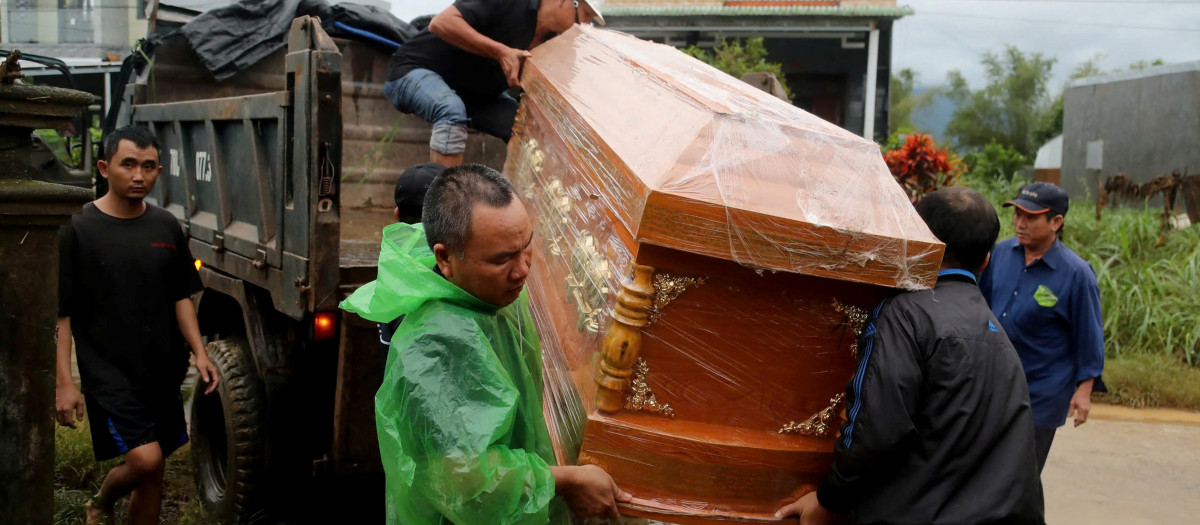 Los hombres descargan un ataúd de un camión antes del funeral de una persona que murió en las inundaciones en la comuna de Hoa Thinh, provincia de Dak Lak, en el centro de Vietnam