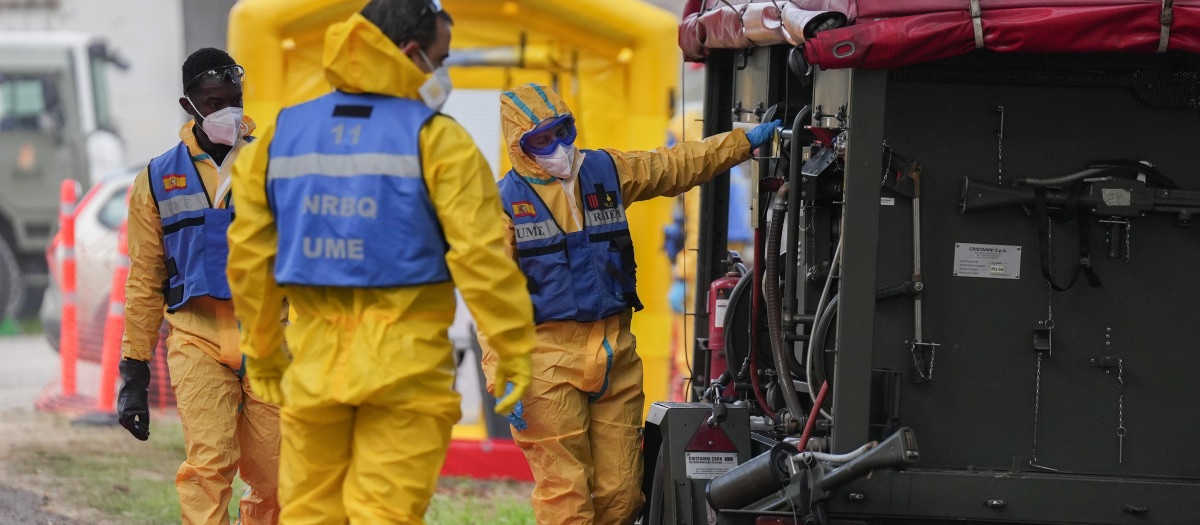 Varias personas de la UME desinfectan vehículo para el control de la peste porcina en Barcelona (Cataluña)