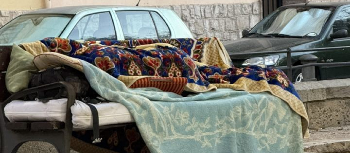 Imagen de archivo de un indigente durmiendo en un banco de Alicante