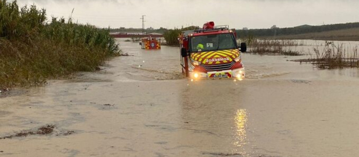 Un vehículo de Bomberos en un camino inundado en Huelva