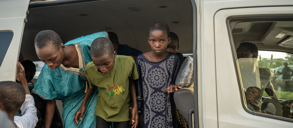 Algunos de los estudiantes rescatados bajan de un minibús al llegar a la oficina del gobernador local en el 8 de diciembre