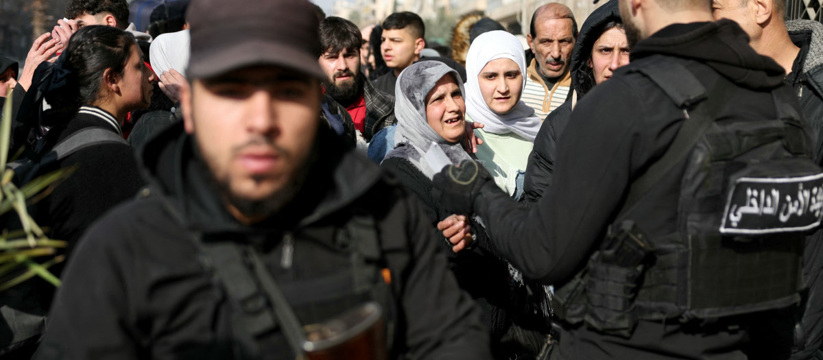 Las fuerzas de seguridad sirias escoltan a residentes que huyen de los barrios predominantemente kurdos de Sheikh Maqsud y Ashrafiyeh en la ciudad de Alepo, al norte de Siria