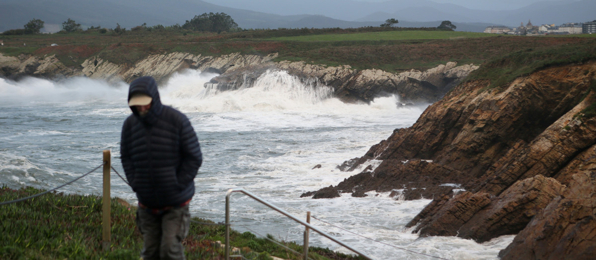 Cospeito y Ribadeo, Lugo. La borrasca Domingos descarga con fuerza lluvia y viento huracanado sobre el norte peninsular. Diversas localidades de A Terra Chá, como Triabá, en Cospeito, han visto cómo las fuertes lluvias han provocado el desbordamiento de ríos como el Támega, Anllo o el propio río Miño. En A Mariña, vientos de más de 100 km/h y oleaje de más de 8 metros mantienen alerta roja anunciada por AEMET. En la imagen, un hombre camina por un sendero junto a la costa durante un fuerte oleaje en Ribadeo, en la tarde del sábado 4 de noviembre