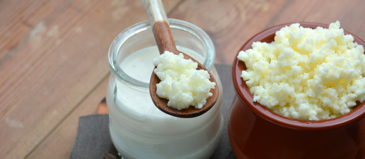 full of keffir, milk and yogurt cups liquid on wooden table