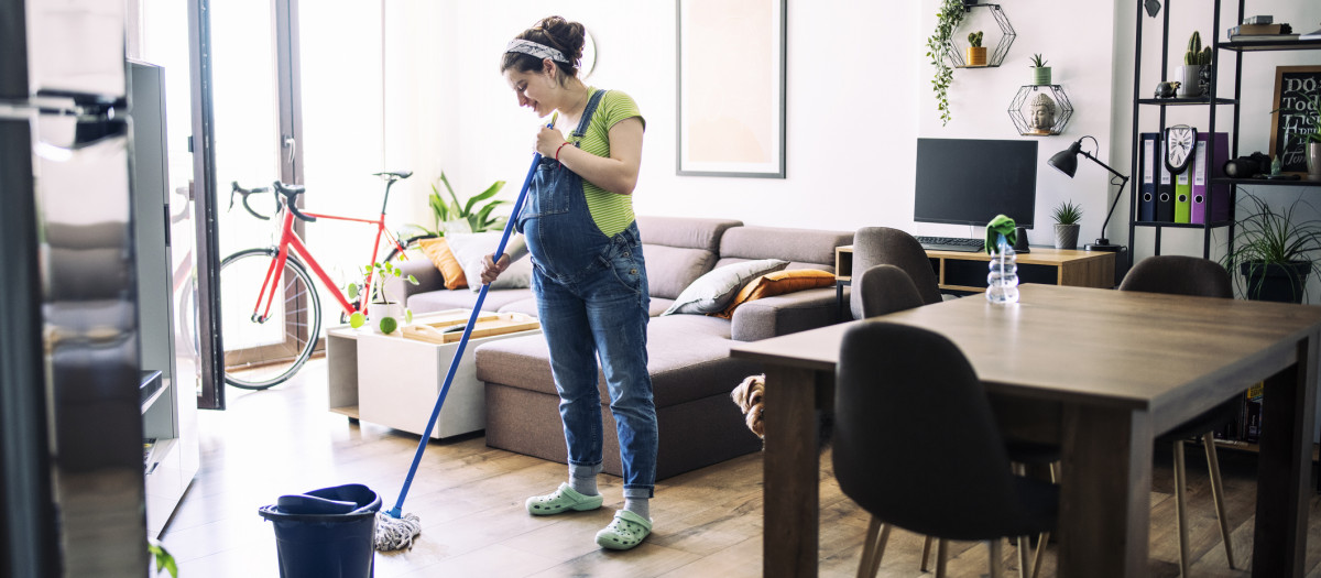 Una mujer embarazada pasando la fregona