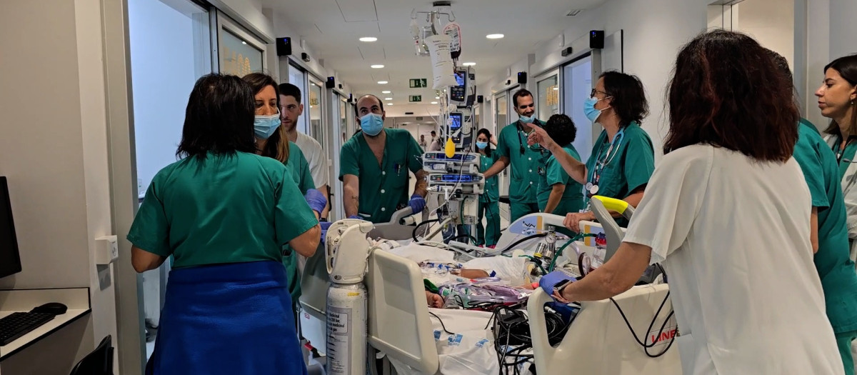 Varios sanitario llevan una cama en el hospital 12 de Octubre