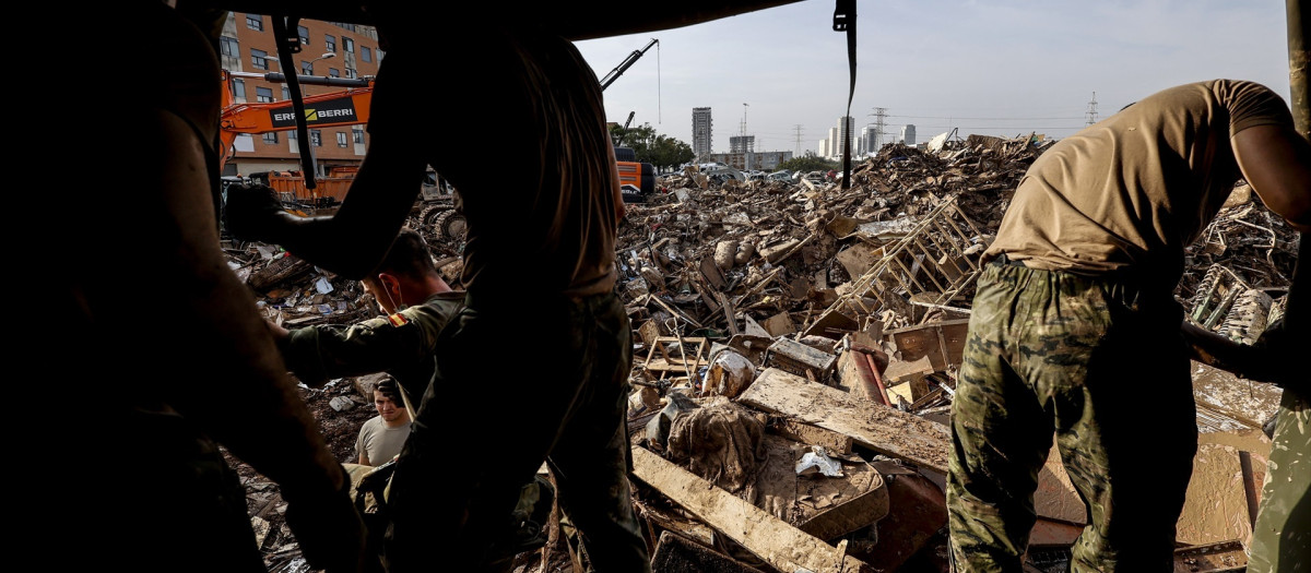 Imagen de archivo de varias personas caminando sobre escombros en Sedaví tras el paso de la dana
