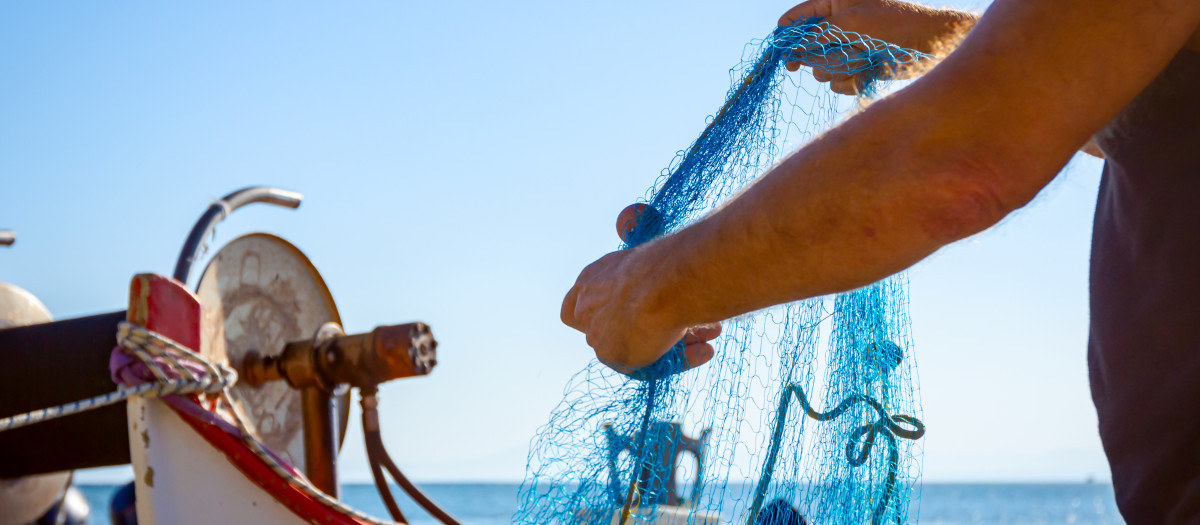Un pescador amontona las redes