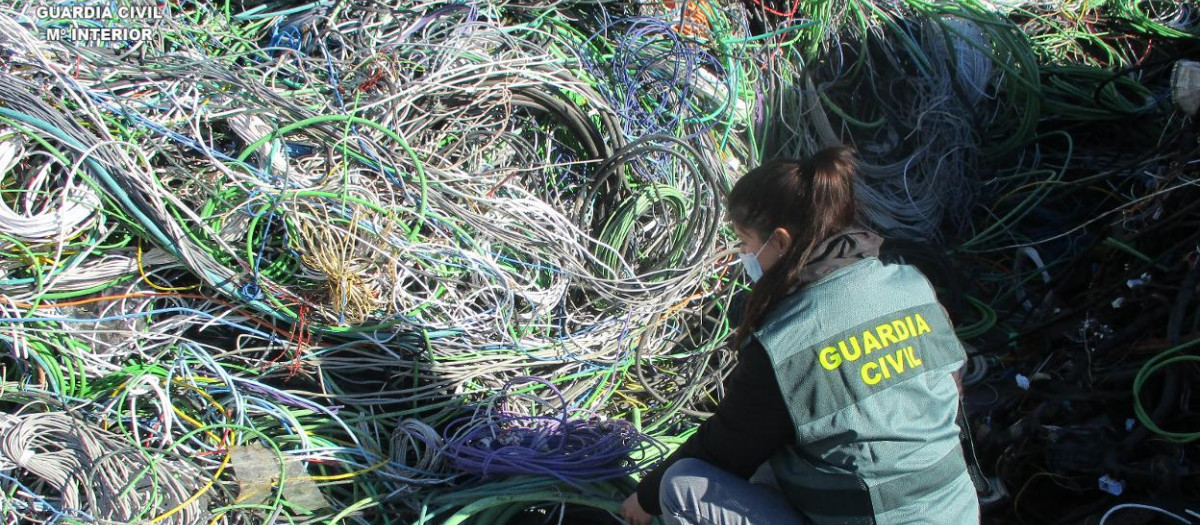 Un agente de la Guardia Civil ante numerosos cables de cobre robados
