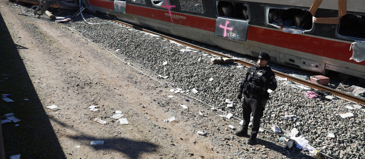 Un agente de la Guardia Civil ante el tren Iryio que circulaba en sentido Madrid siniestrado en el accidente ferroviario ocurrido el pasado domingo