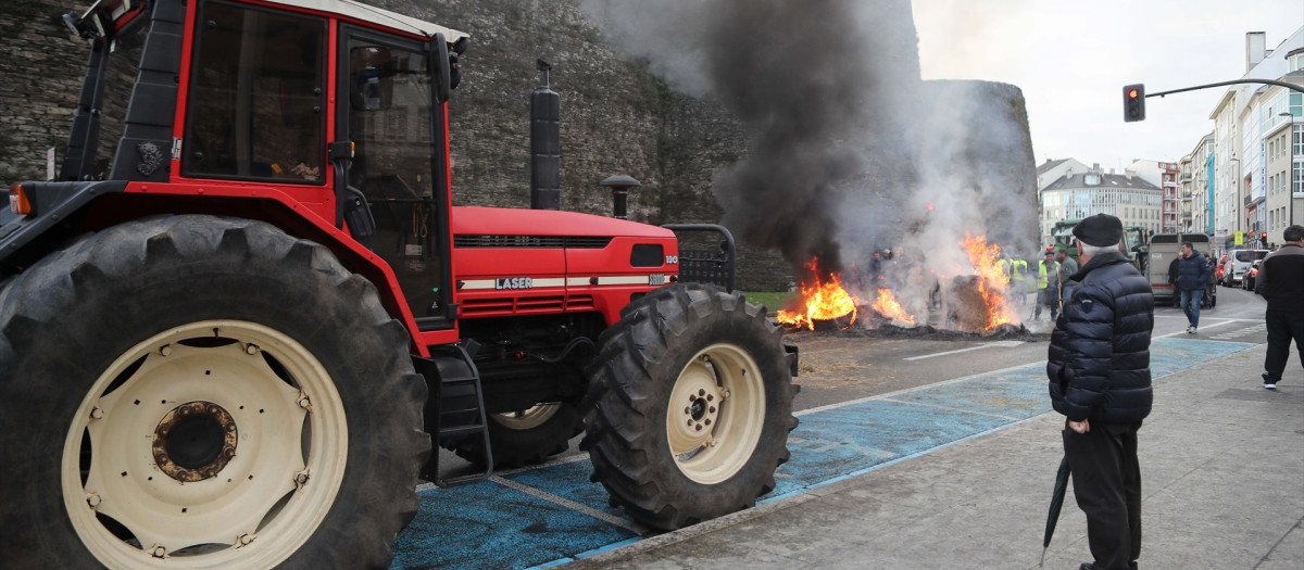 Hoguera de manifestantes de la tractorada que rodea la Muralla de Lugo desde el pasado lunes, frente a la Delegación de la Xunta de Galicia en Lugo, a 14 de enero de 2026, en Lugo, Galicia (España). Los ganaderos y agricultores gallegos continúan en pie de guerra contra el acuerdo comercial de Mercosur y la Unión Europea. Continúan con la protesta desde el lunes, reuniendo en la ciudad hasta 140 tractores. Afiliados a Agromuralla y Gandeiros Galegos da Suprema mantienen un retén de manifestantes ante el edificio de la Xunta y más de medio centenar de tractores aparcados en la ronda de la Muralla.

Carlos Castro / Europa Press
14/1/2026