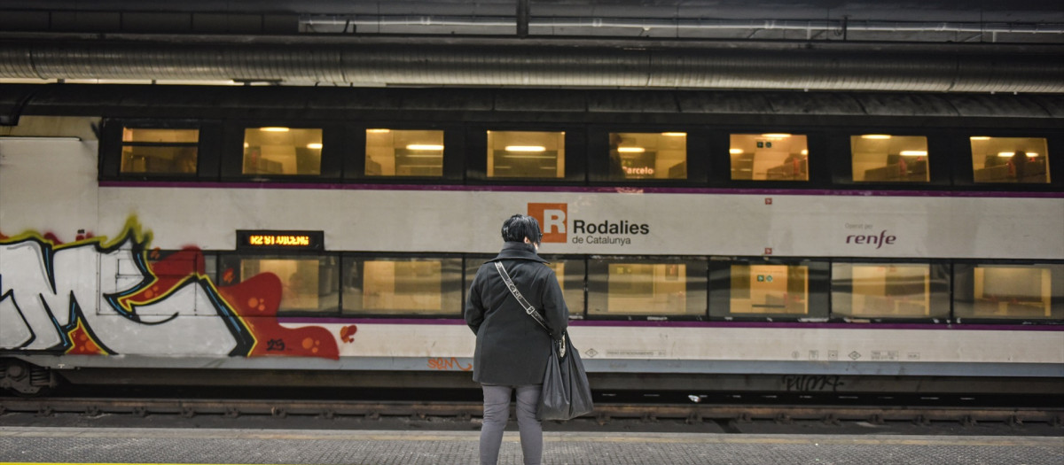 Una mujer espera un tren de Rodalies, en la estación de Sants de Barcelona
