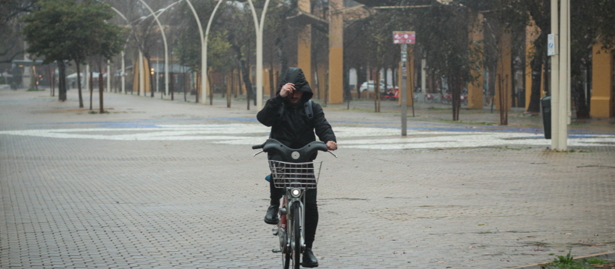 Imagen de archivo de un ciclista protegiéndose del viento y la lluvia