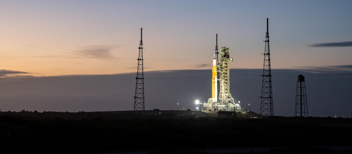 El cohete del Sistema de Lanzamiento Espacial Artemisa II (SLS) de la NASA y la nave espacial Orión se ven iluminados por luces en el Complejo de Lanzamiento 39B