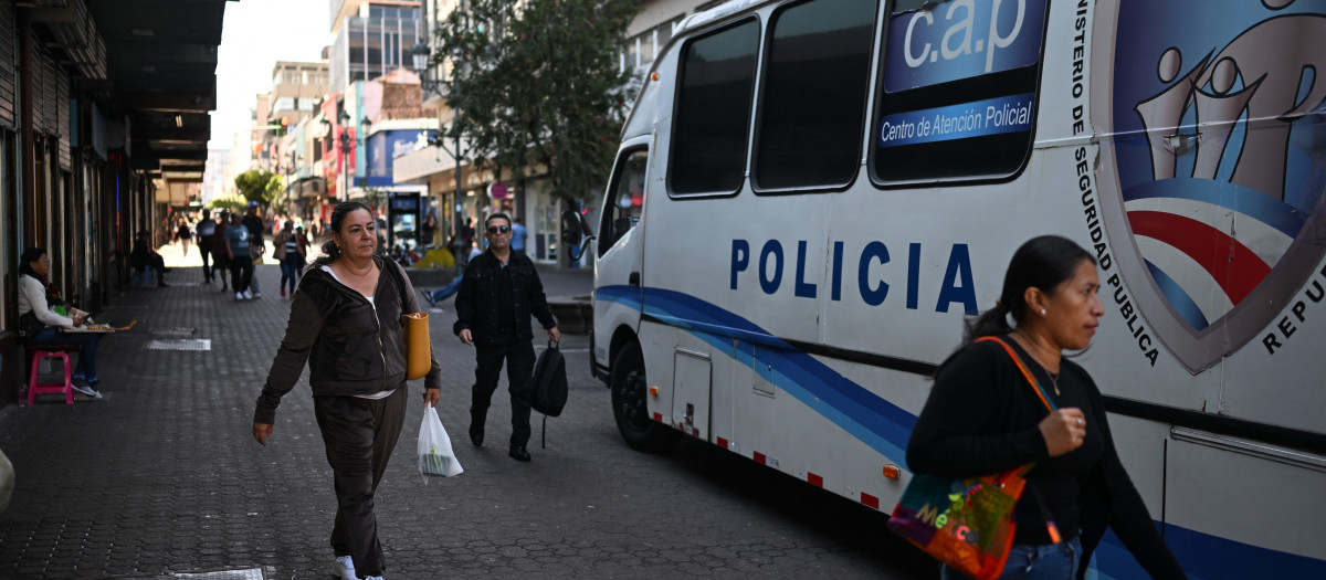 Varias personas caminan frente a una oficina móvil de la policía en San José, la capital de Costa Rica