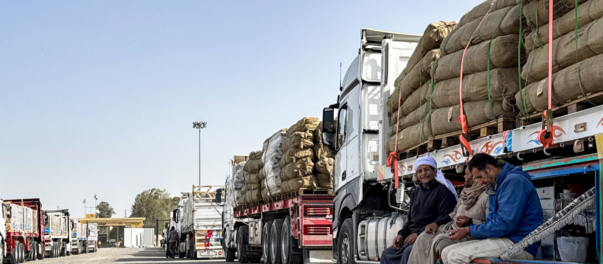 Camioneros esperan junto a sus vehículos, que transportan ayuda humanitaria, antes de entrar por el lado egipcio del cruce fronterizo de Rafah con la Franja de Gaza, en el noreste de Egipto