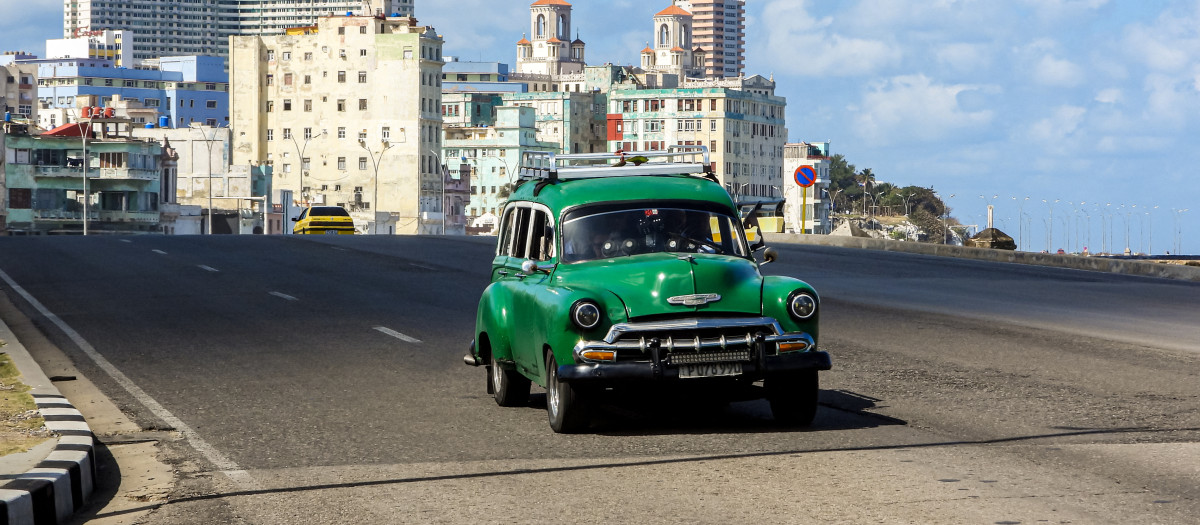 An old American car drives along a quiet avenue in Havana on February 8, 2026. The Cuban government on February 6 announced emergency measures to address a crippling energy crisis worsened by US sanctions, including the adoption of a four-day work week for state-owned companies and fuel sale restrictions. (Photo by ADALBERTO ROQUE / AFP)