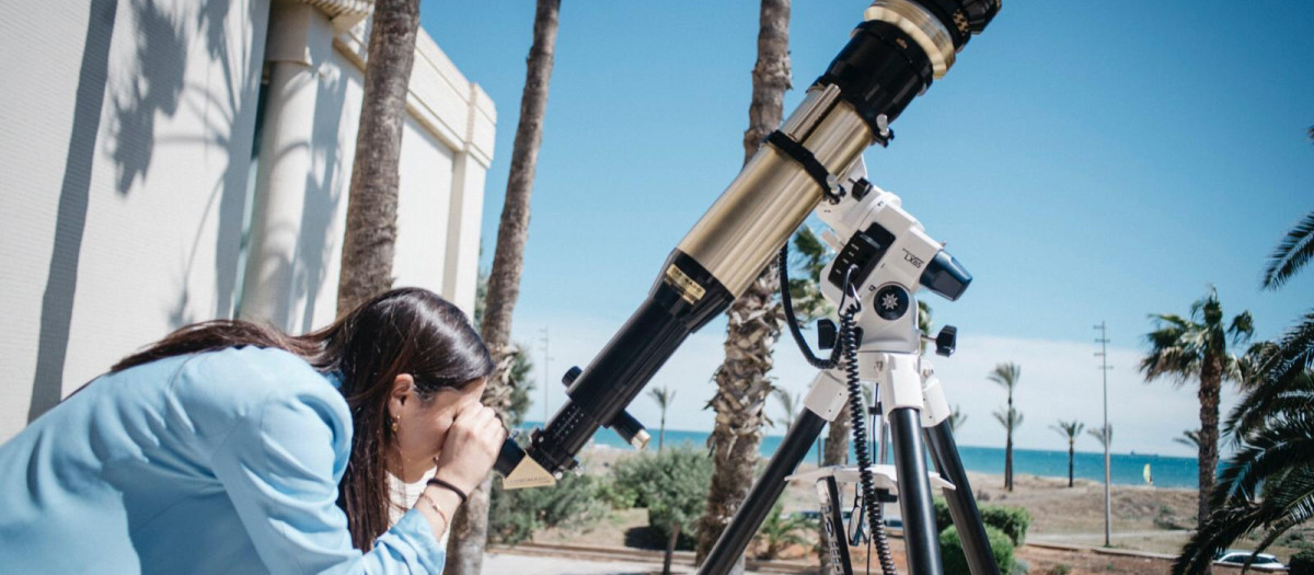 Imagen de archivo de una mujer mirando por un telescopio en el Grao de Castellón