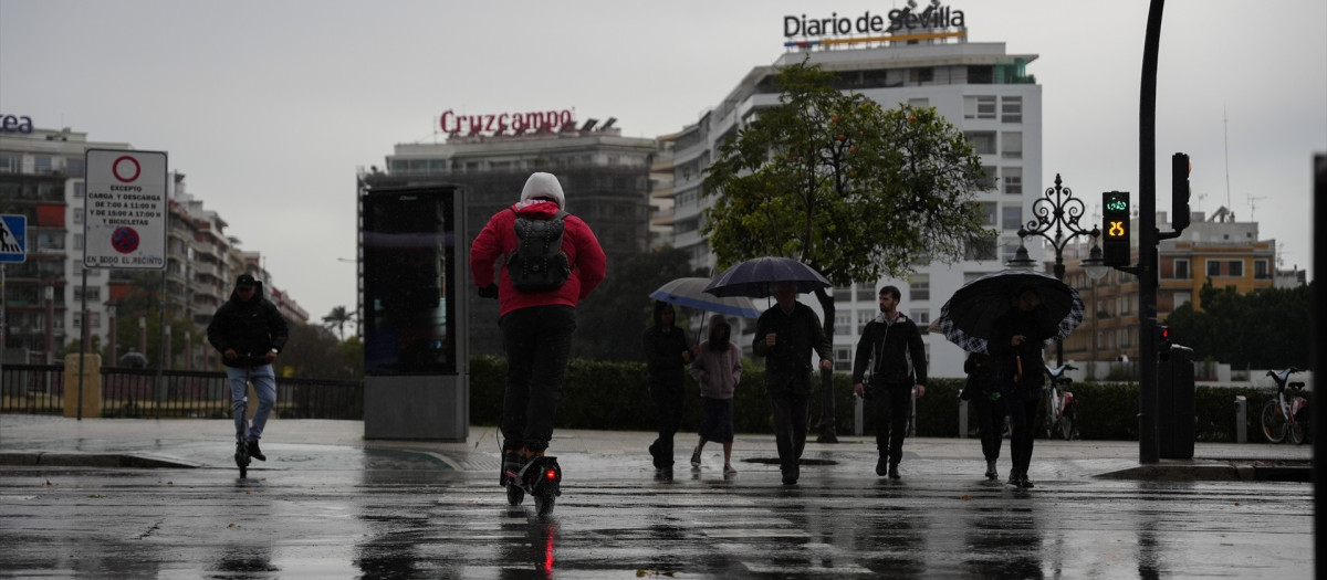 Peatones se protegen de la lluvia bajo sus paraguas