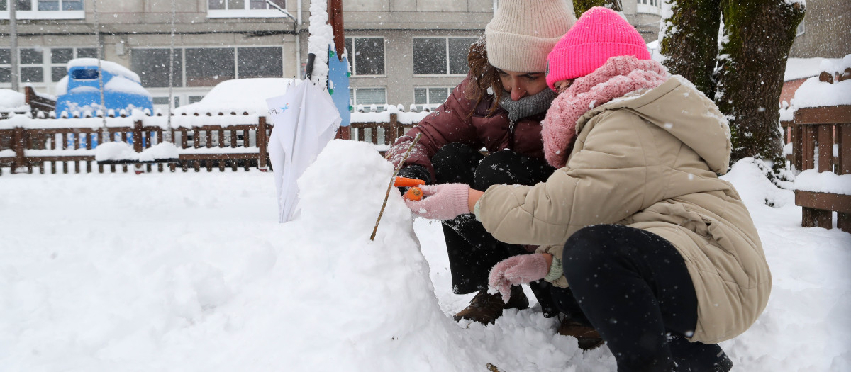 Unos niños juegan con la nieve en Lugo