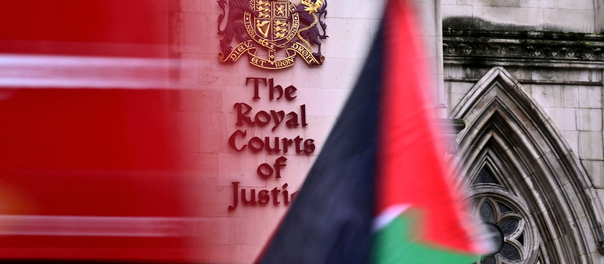 Una bandera palestina es ondeada por un manifestante afuera de los Tribunales Reales de Justicia, el Tribunal Superior de Gran Bretaña, en Londres
