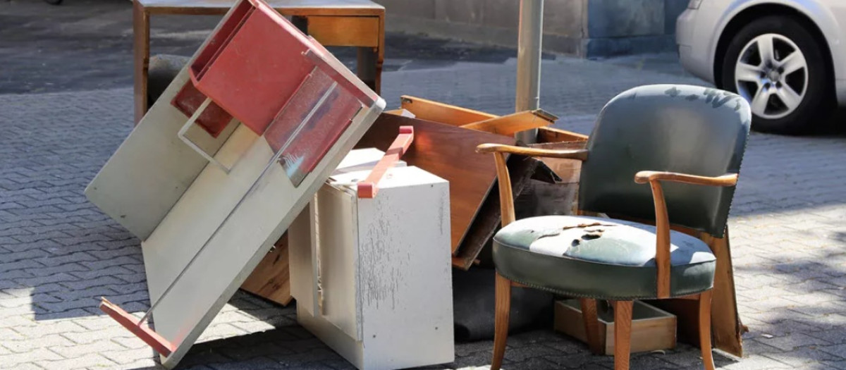 Muebles inservibles apilados en la calle