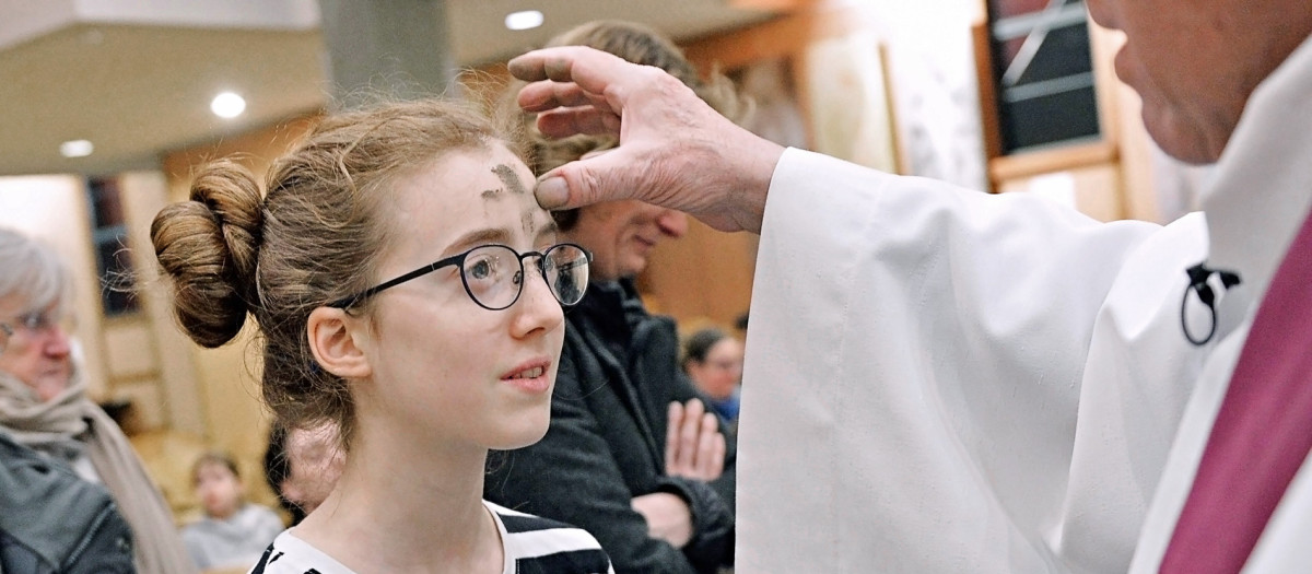 Un sacerdote impone la ceniza a una niña durante un servicio el Miércoles de Ceniza, en la iglesia de Notre-Dame d'Esperance en París.