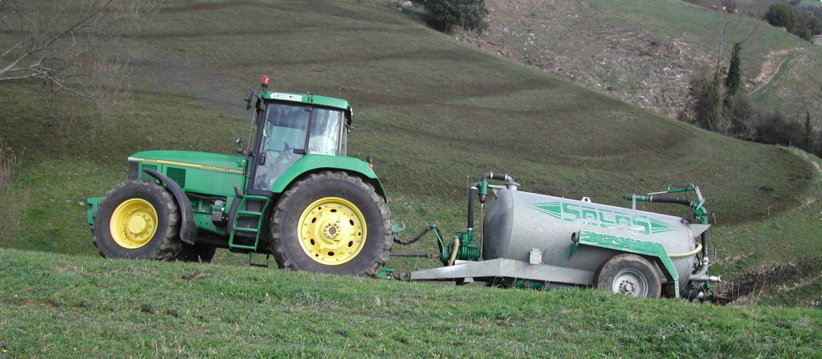 Un tractor aplica fertilizantes sobre la tierra