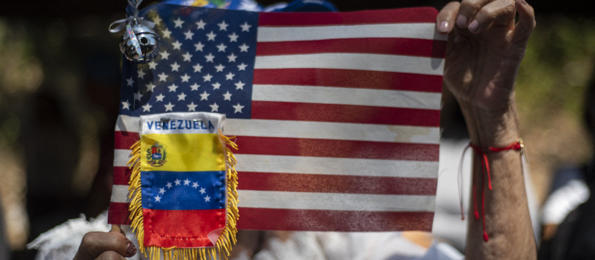 Manifestantes sostienen banderas de Venezuela y Estados Unidos durante una marcha estudiantil para exigir la liberación de los presos políticos en el Día Nacional de la Juventud en Caracas, Venezuela
