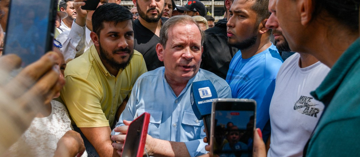 Juan Pablo Guanipa habla con un periodista rodeado de simpatizantes frente a la Basílica de la Virgen de La Chinita en Maracaibo
