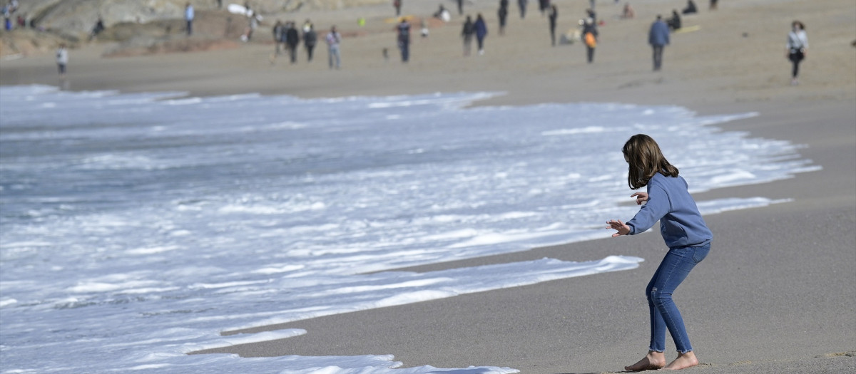 Varias personas disfrutan de un día de primavera anticipada con temperaturas de  20 ºC de máxima en la playa del Orzán en La Coruña