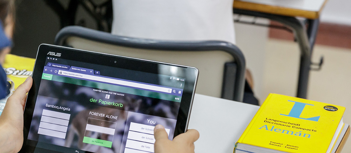 Imagen de archivo de unos estudiantes utilizando un dispositivo móvil en el aula