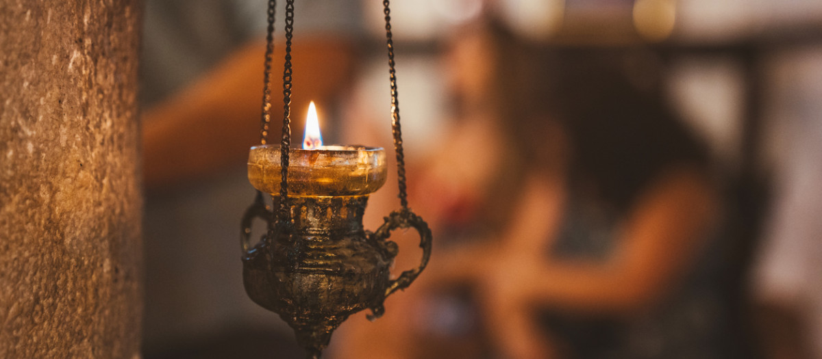Una vela encendida sobre un candil colgante