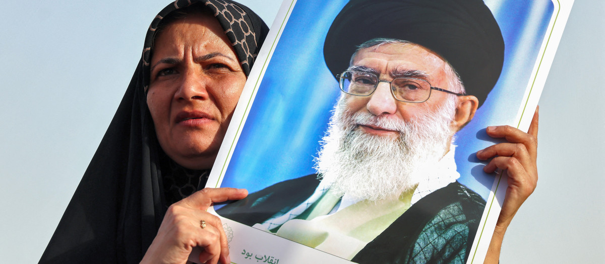 An Iranian woman holds a portrait of supreme leader Ayatollah Ali Khamenei as people celebrate a ceasefire between Iran and Israel at Enghlab Square in the capital Tehran on June 24, 2025. A fragile ceasefire in the Iran-Israel war appeared to be holding on June 24, after 12 days of strikes that saw Israel and the United States pummel the Islamic republic's nuclear facilities. (Photo by ATTA KENARE / AFP)