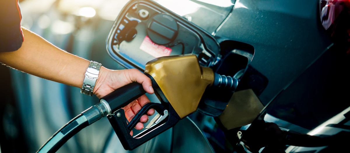 Un señor repostando gasolina en una estación de servicio