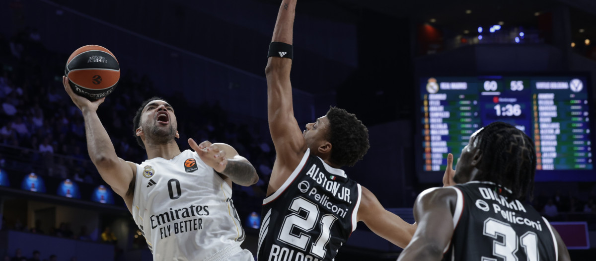 MADRID, 05/03/2026.- El alero canadiense del Real Madrid Trey Lyles (i) lanza a canasta ante Derrick Alston Jr. (c), de la Virtus de Bolonia, durante el partido de la EuroLiga que Real Madrid y Virtus de Bolonia disputan este jueves en el Movistar Arena, en Madrid. EFE/Juanjo Martín
