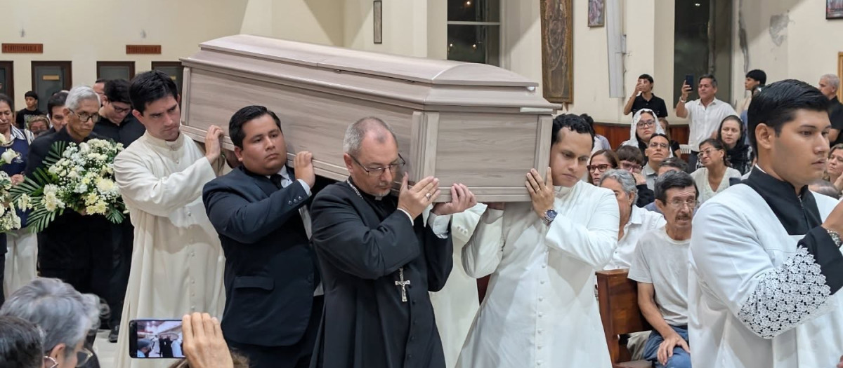 Algunos fieles y sacerdotes cargan con el ataúd del padre
