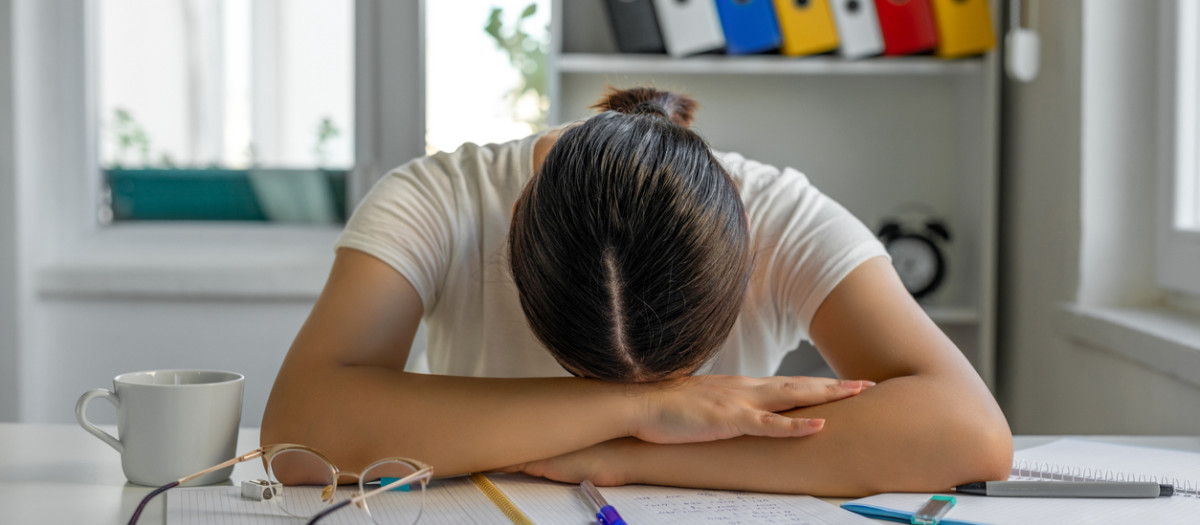 Chica cansada durmiendo en su escritorio durante el trabajo