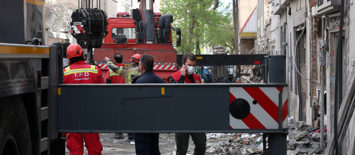 omberos buscan víctimas e inspeccionan los daños en un edificio residencial al sur de Teherán