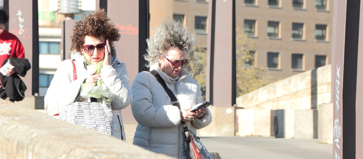 Dos mujeres pasean en medio de una fuerte racha de viento, en una imagen de archivo